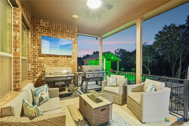 a view of a patio with couches chairs potted plants and wooden floor
