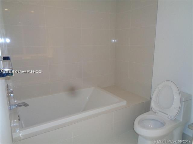 45 Southwest 9th Street, Unit 2709 Miami, FL 33130 - Photo 11 of 34 a white bath tub sitting next to a toilet