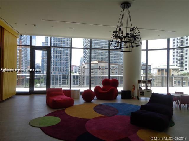 45 Southwest 9th Street, Unit 2709 Miami, FL 33130 - Photo 23 of 34 a living room with furniture and a floor to ceiling window