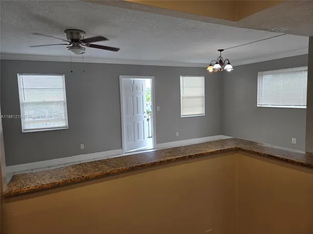 a view of a livingroom with a ceiling fan and window
