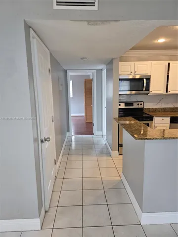 a kitchen with granite countertop a refrigerator and a stove