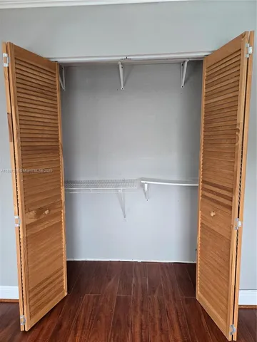 a view of walk in closet with wooden floor
