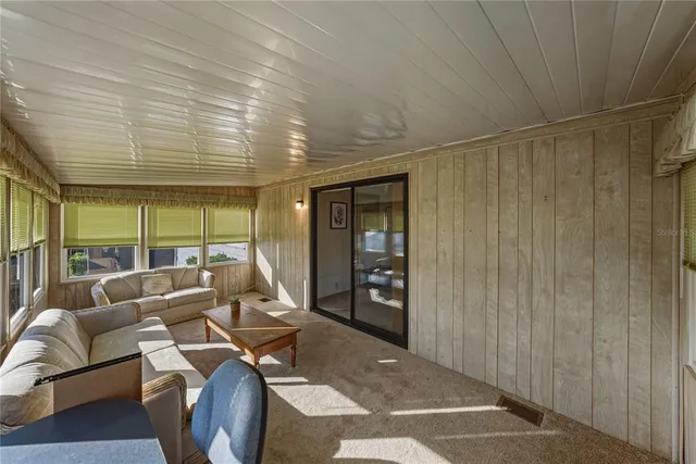 a living room with furniture and large windows