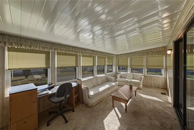 a living room with furniture and a floor to ceiling window