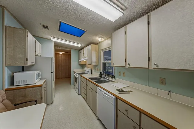 a kitchen with stainless steel appliances a stove a sink and a refrigerator