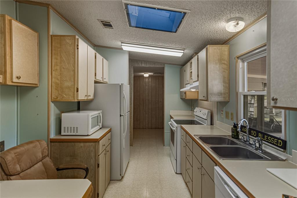 14921 Rialto Avenue Brooksville, FL 34613 - Photo 20 of 55 a kitchen with a sink a stove and cabinets