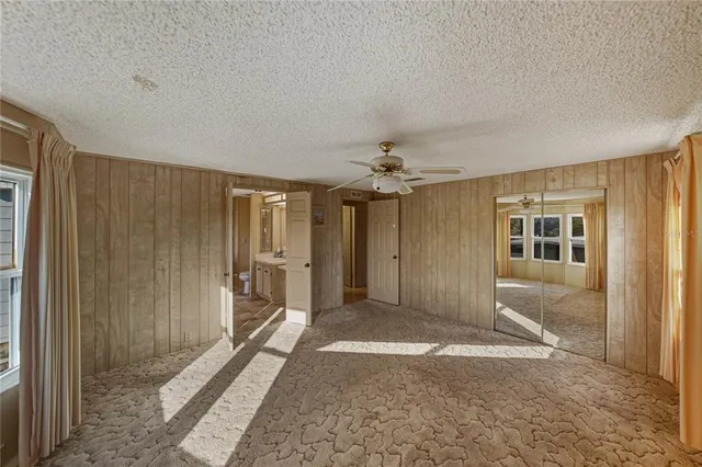 a spacious bathroom with a granite countertop sink toilet a mirror and shower