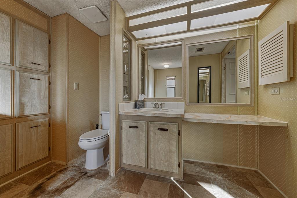 14921 Rialto Avenue Brooksville, FL 34613 - Photo 31 of 55 a spacious bathroom with a granite countertop sink toilet a mirror and shower