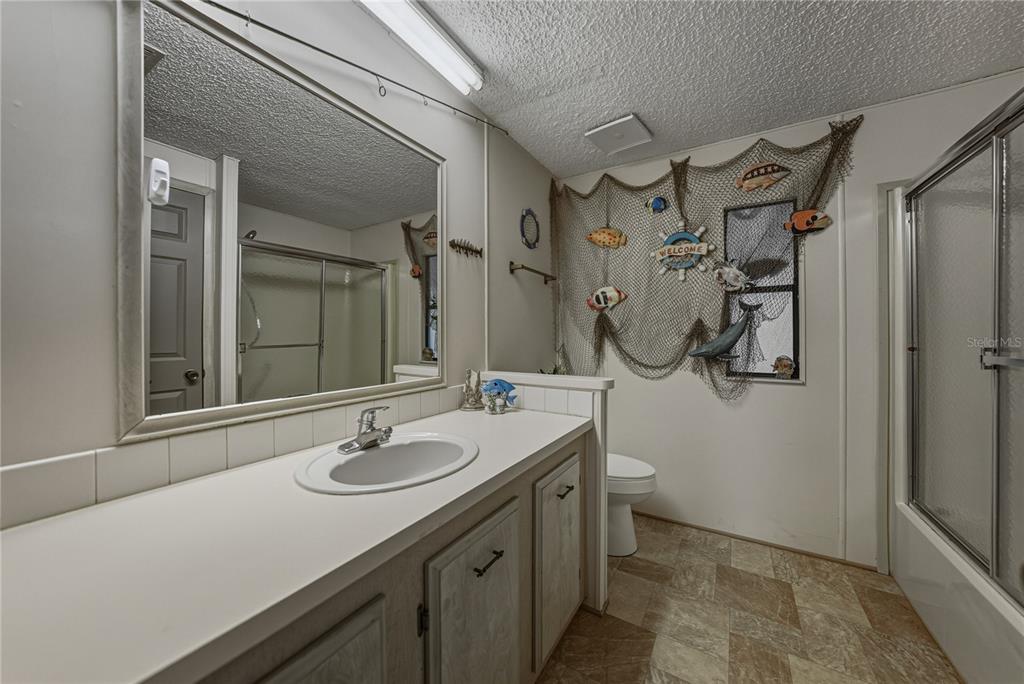 14921 Rialto Avenue Brooksville, FL 34613 - Photo 37 of 55 a bathroom with a sink and mirror with toilet