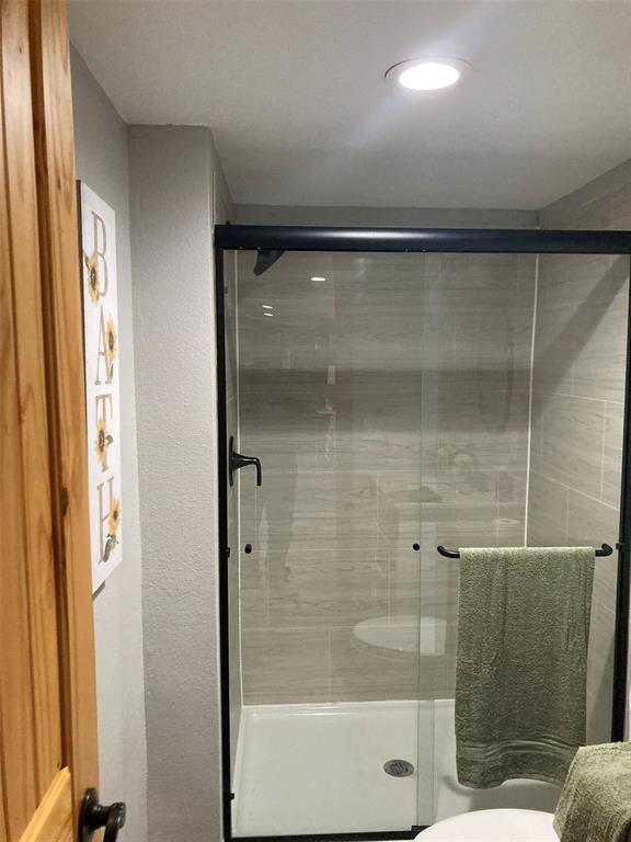 248 Shaffer Road Denison, TX 75021 - Photo 16 of 39 a bathroom with a glass shower door