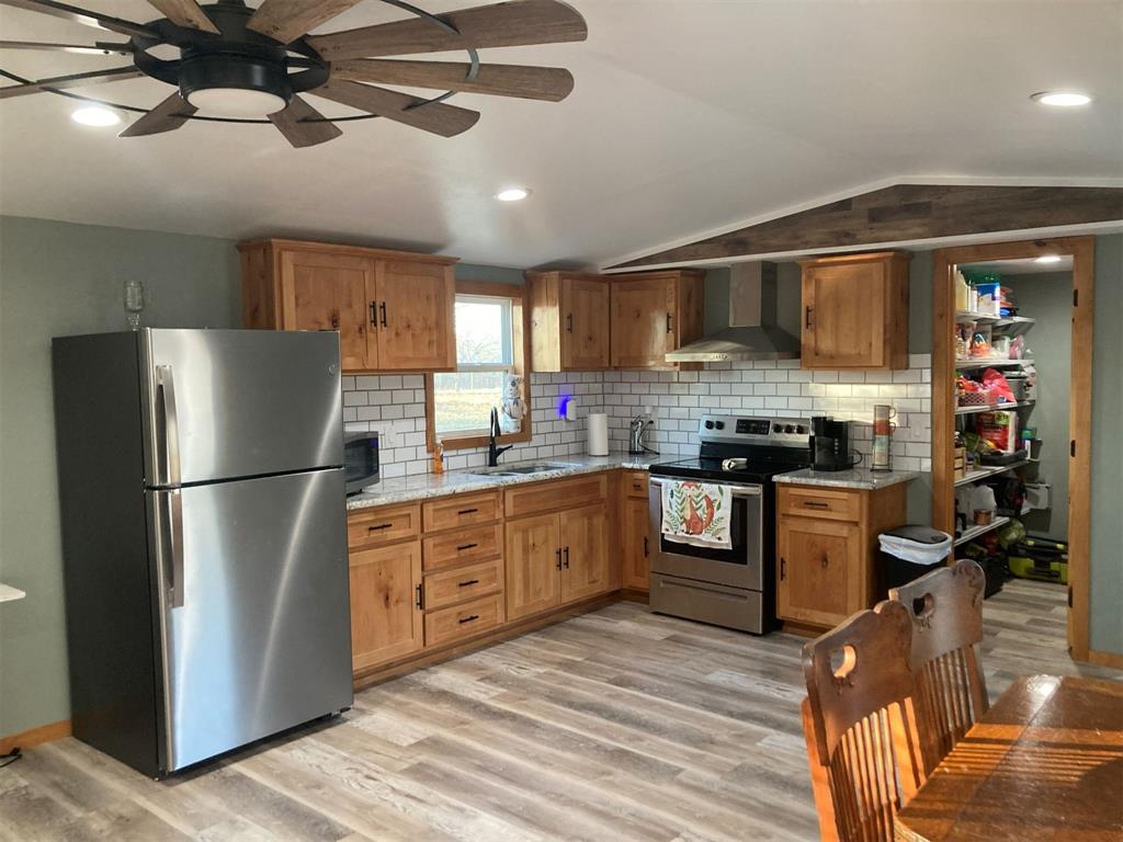 248 Shaffer Road Denison, TX 75021 - Photo 7 of 39 a kitchen with a refrigerator a stove top oven a sink and dishwasher with wooden floor