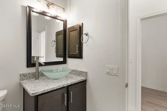 a bathroom with a granite countertop sink and a mirror