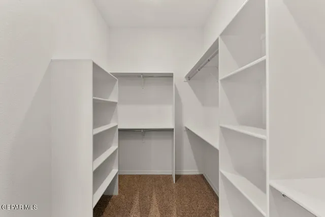 a view of walk in closet with empty racks