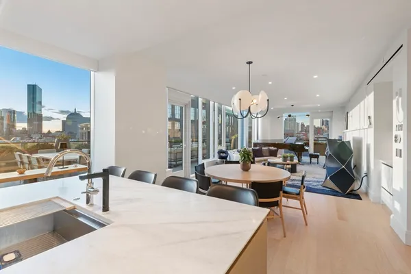 a large white kitchen with a large window and chandelier