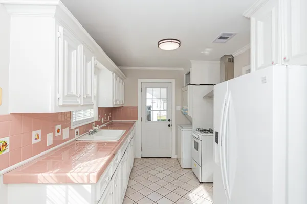 a white kitchen with a stove top oven