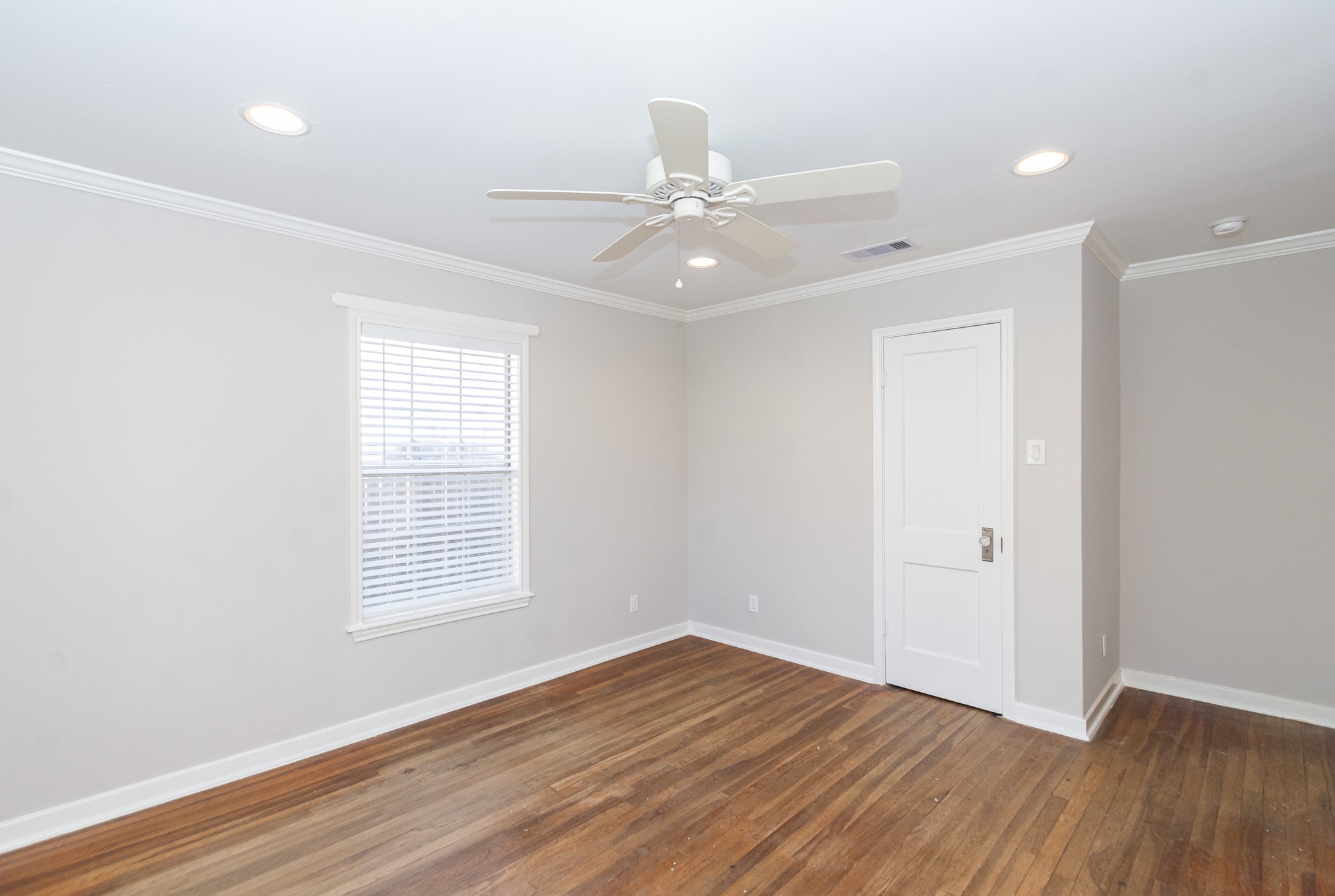 7447 Magnolia Street Houston, TX 77023 - Photo 21 of 38 an empty room with wooden floor ceiling fan and windows