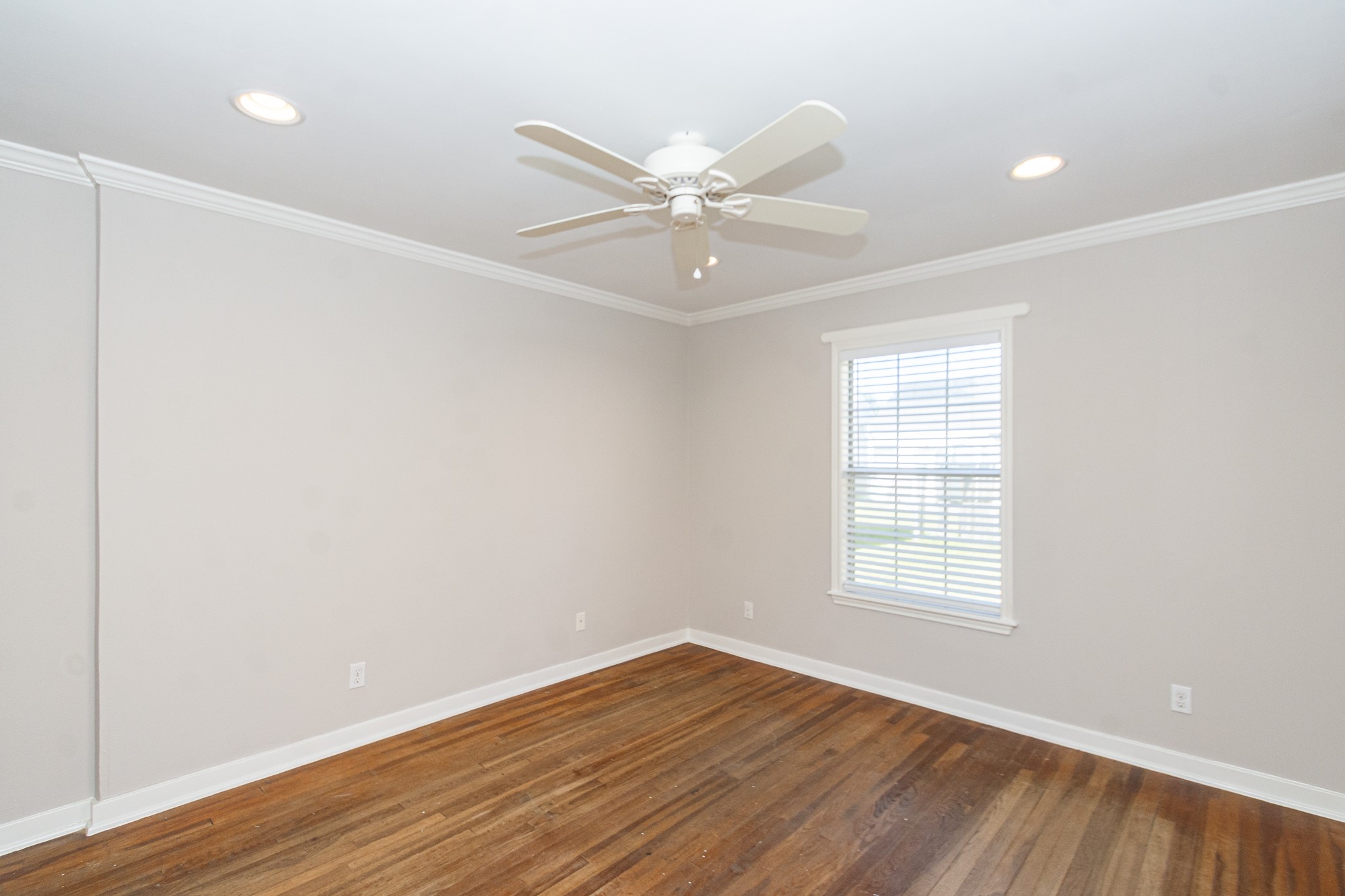 7447 Magnolia Street Houston, TX 77023 - Photo 22 of 38 an empty room with wooden floor fan and windows