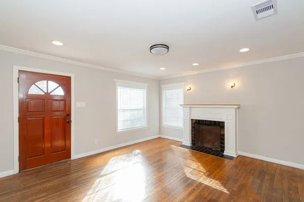 an empty room with windows and fireplace