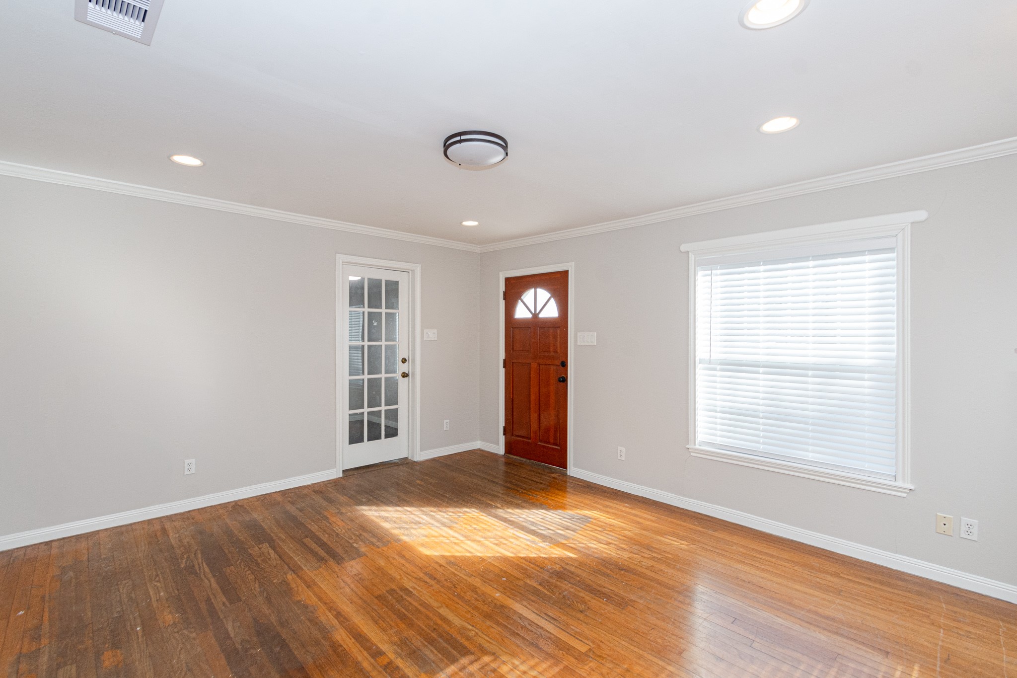 7447 Magnolia Street Houston, TX 77023 - Photo 7 of 38 an empty room with wooden floor and windows