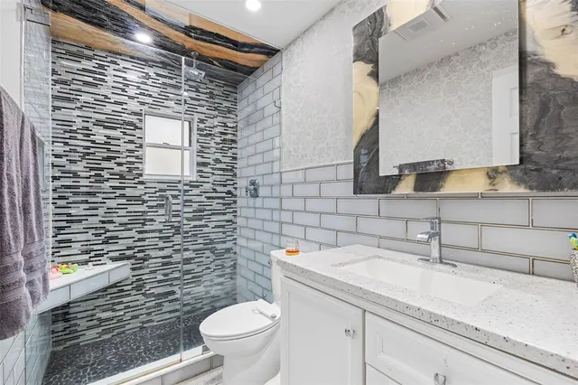 a bathroom with a sink a toilet and mirror