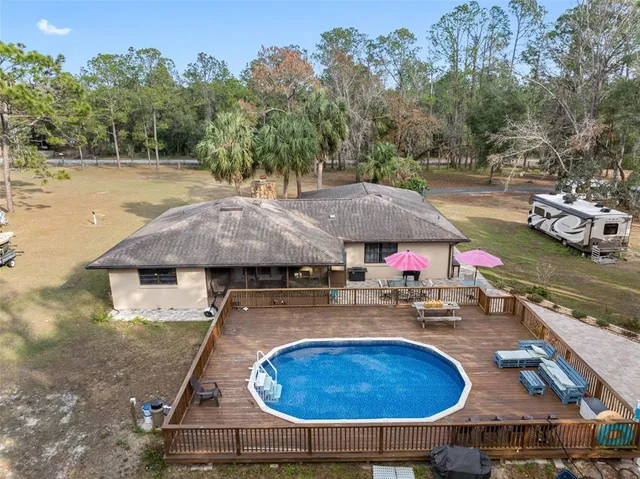 an aerial view of a house with swimming pool and patio