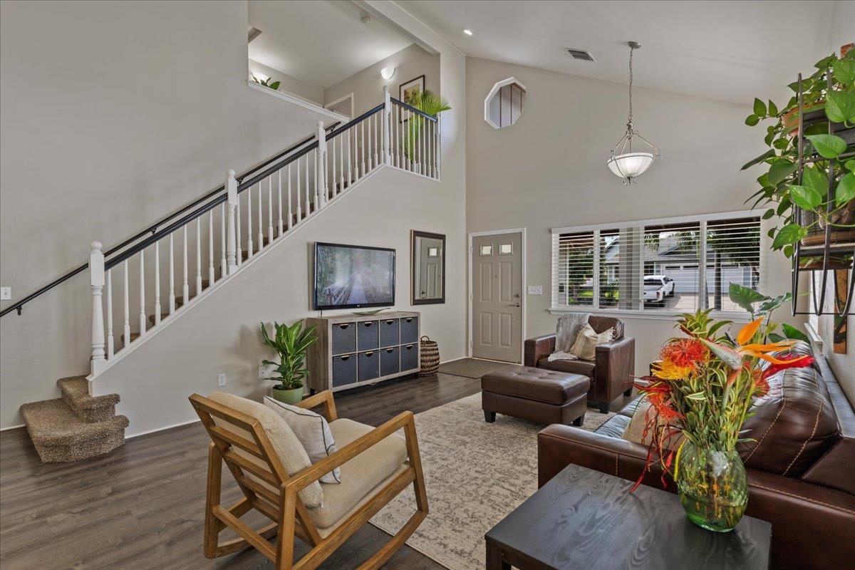 a living room with furniture a chandelier and a dining table