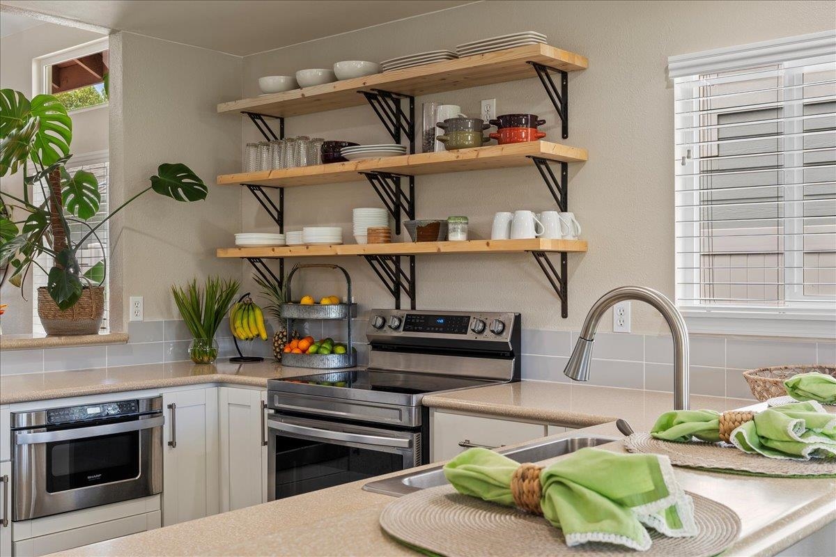 28 Papahi Loop Kahului, HI 96732 - Photo 16 of 50 a kitchen with stainless steel appliances a stove and a wooden floor