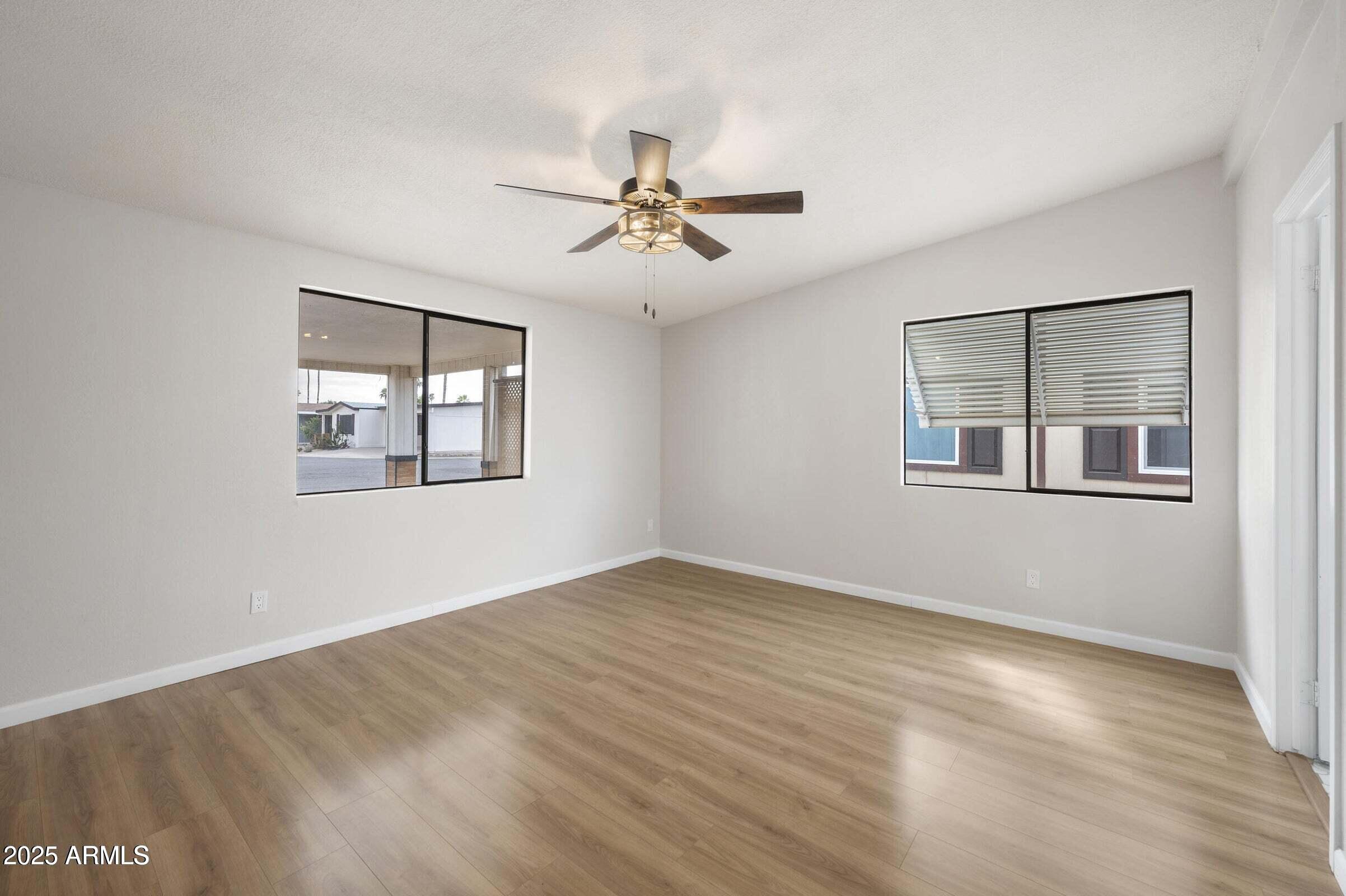 3500 South Tomahawk Road, Unit 126 Apache Junction, AZ 85119 - Photo 20 of 38 a view of empty room with wooden floor and fan