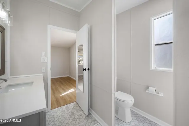 a bathroom with a granite countertop sink and a toilet