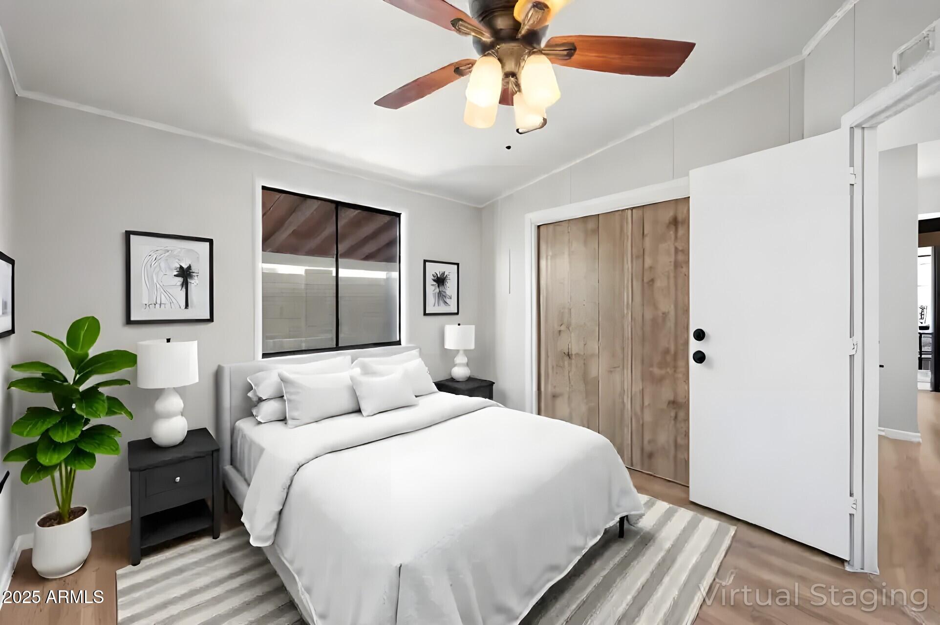 3500 South Tomahawk Road, Unit 126 Apache Junction, AZ 85119 - Photo 23 of 38 a bedroom with a large bed and a chandelier