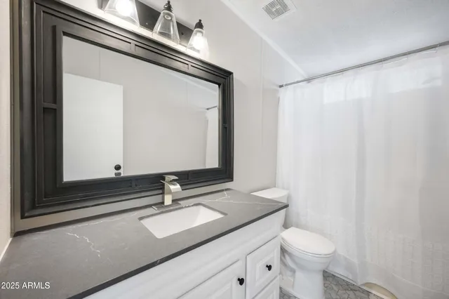 a bathroom with a sink a toilet and a mirror