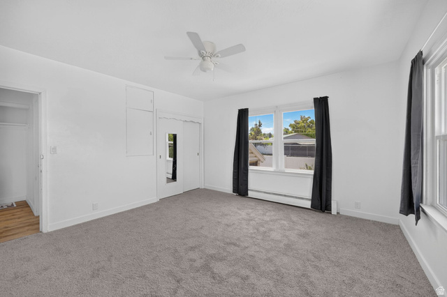 220 East Greenwood Avenue Midvale, UT 84047 - Photo 14 of 46 Carpeted room featuring multiple windows with dark curtains, a ceiling fan, and white walls