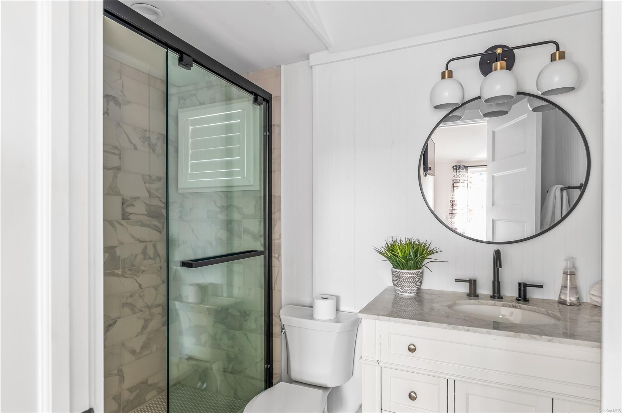 311 Wilmot Road Ocean Beach, NY 11770 - Photo 12 of 12 Bathroom featuring vanity, a shower with shower door, and toilet