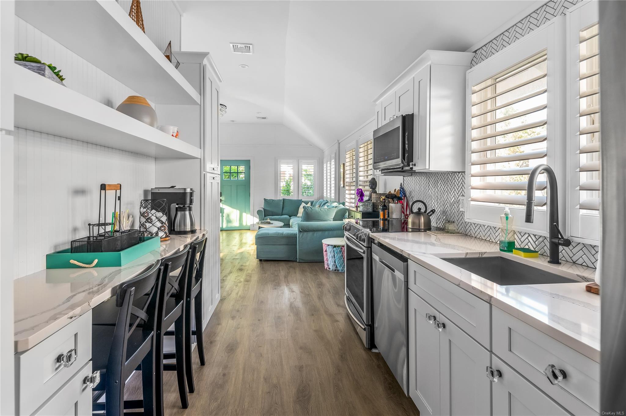 311 Wilmot Road Ocean Beach, NY 11770 - Photo 9 of 12 Kitchen with light stone counters, appliances with stainless steel finishes, vaulted ceiling, and sink