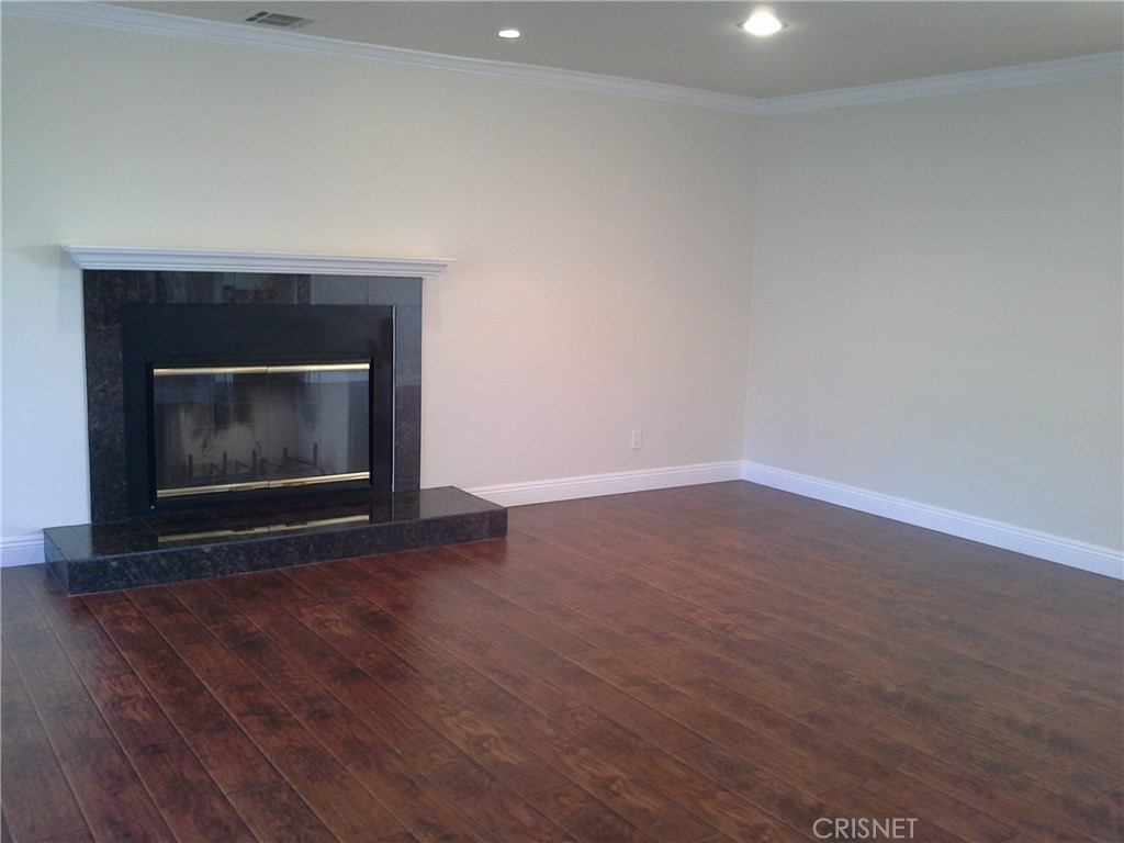 18918 Kinbrace Street Porter Ranch, CA 91326 - Photo 3 of 16 a room with wooden floor a fireplace and a wooden floor