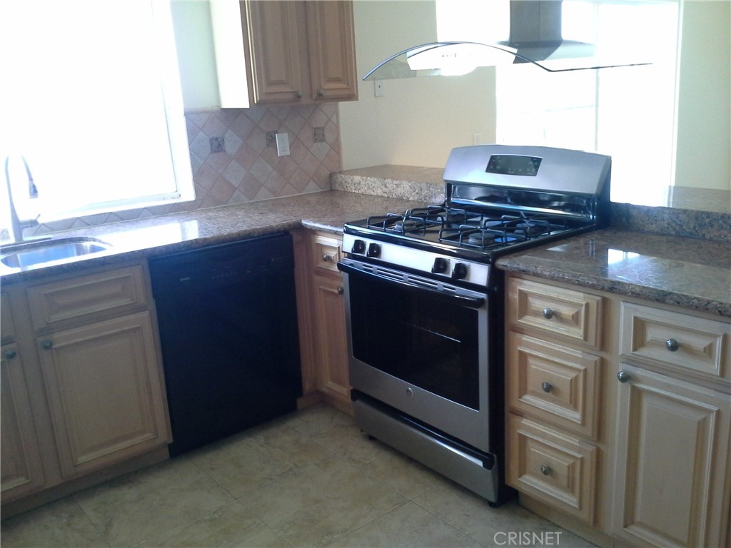 18918 Kinbrace Street Porter Ranch, CA 91326 - Photo 6 of 16 a kitchen with stainless steel appliances granite countertop a stove and a microwave