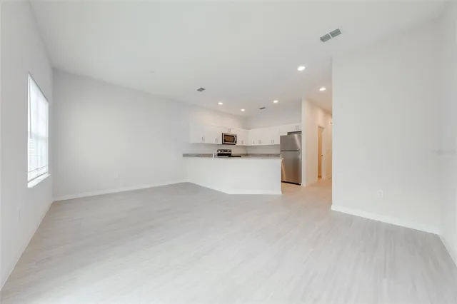 a view of kitchen with kitchen island white cabinetry and wooden floor