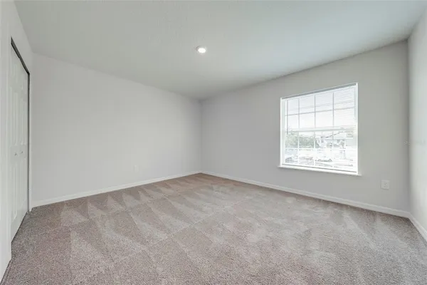an empty room with windows and closet