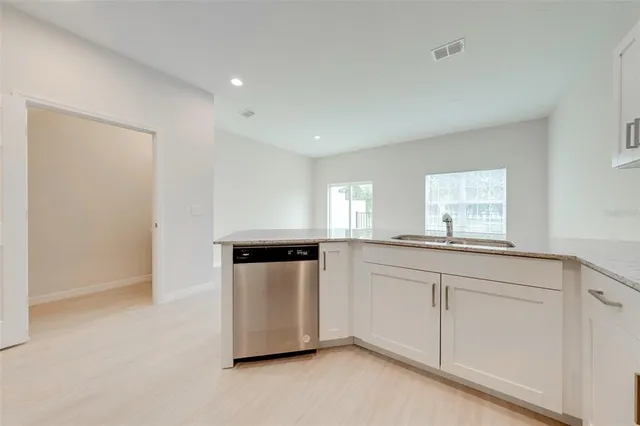 a kitchen with granite countertop white cabinets and white appliances