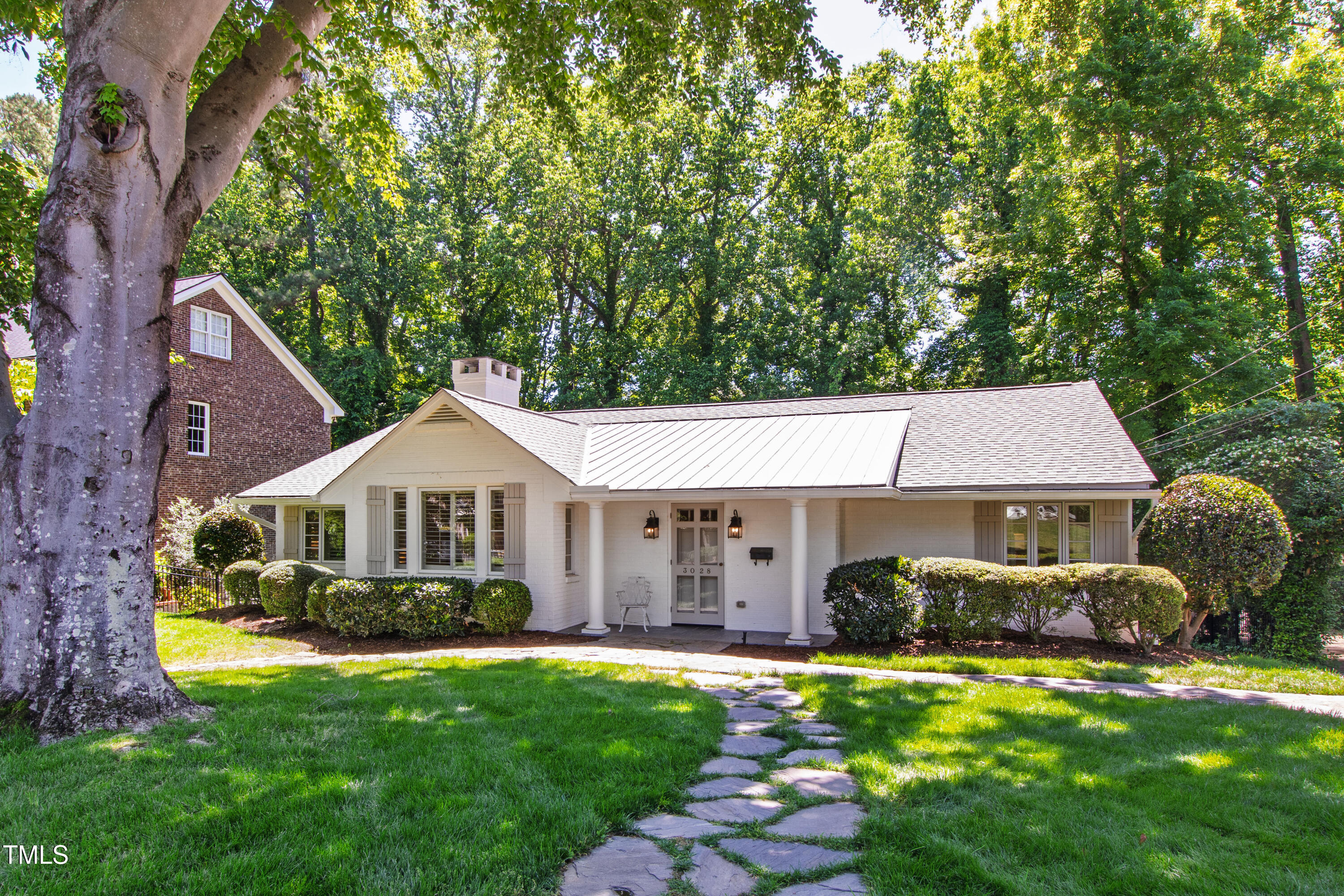 3028 Rothgeb Drive Raleigh, NC 27609 - Photo 1 of 35 a front view of a house with a garden and trees