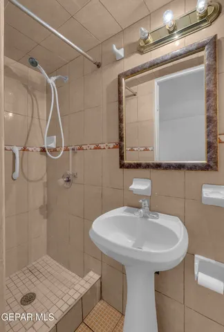 a bathroom with a sink shower and a mirror