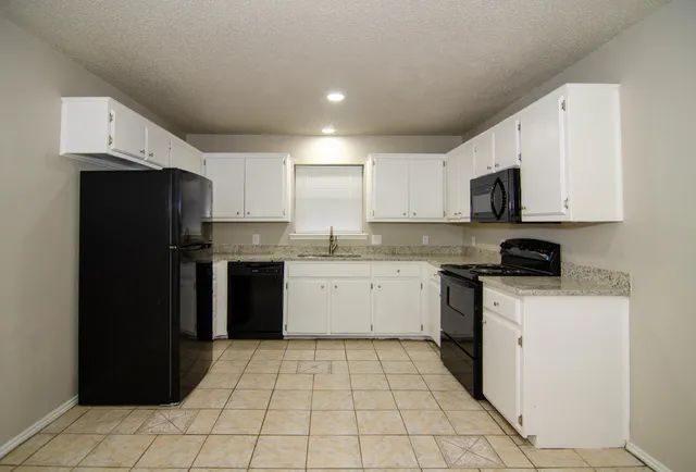 a kitchen with a sink a stove top oven and refrigerator