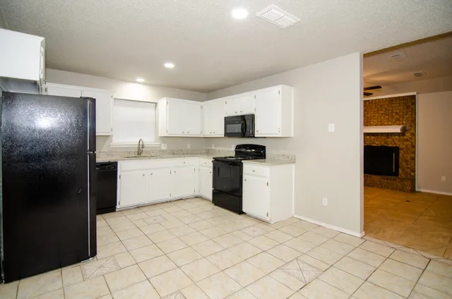 a kitchen with a sink a refrigerator and cabinets