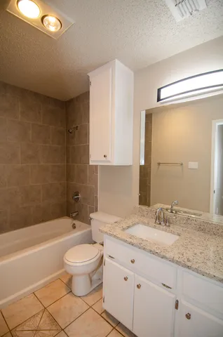 a bathroom with a granite countertop sink toilet a mirror and bathtub
