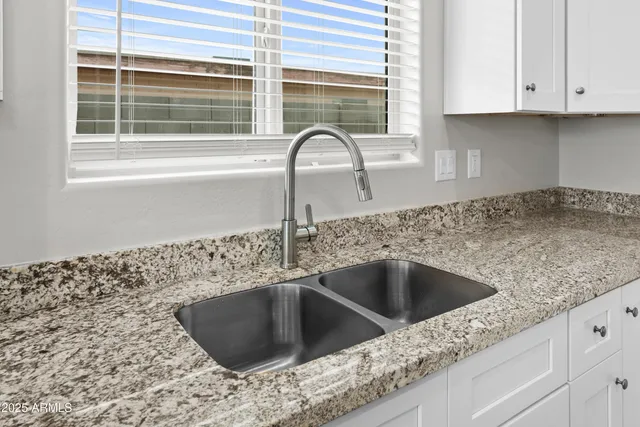 a kitchen with granite countertop a sink and a window