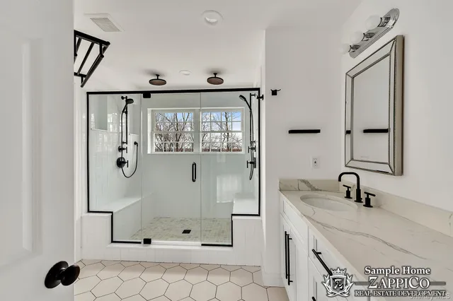 a bathroom with a sink mirror and shower