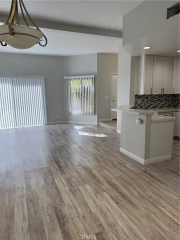 a view of a kitchen with wooden floor and a sink