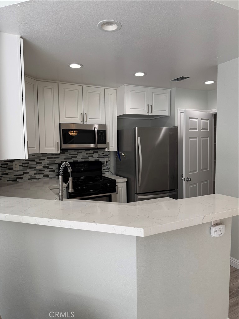 1730 Sinaloa Road Simi Valley, CA 93065 - Photo 4 of 38 a kitchen with stainless steel appliances a refrigerator and a stove top oven