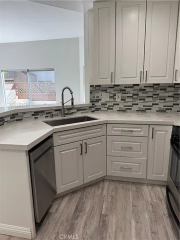 a kitchen with white cabinets and sink