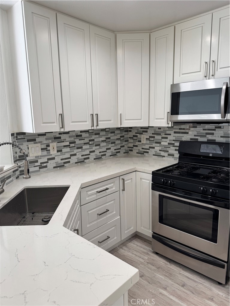 1730 Sinaloa Road Simi Valley, CA 93065 - Photo 7 of 38 a kitchen with granite countertop a stove sink and cabinets